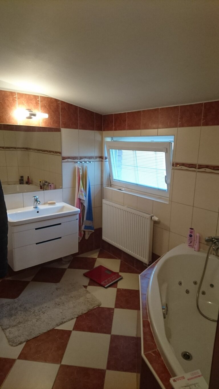 Původní koupelna před rekonstrukcí – hnědý obklad a rohová vana