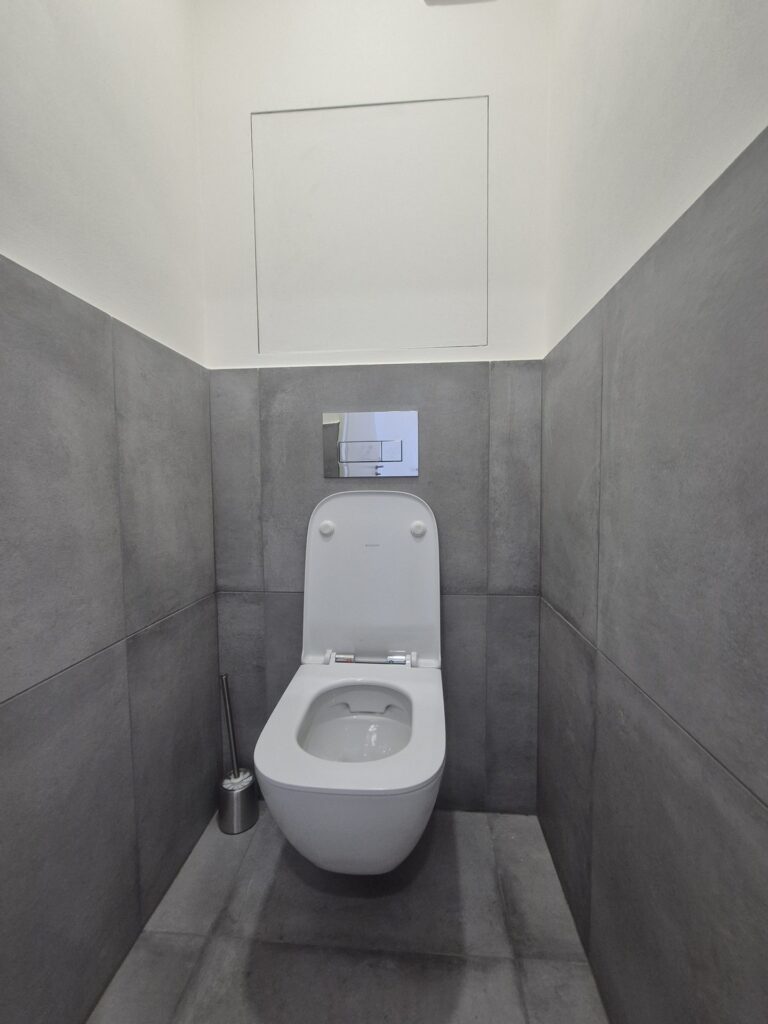 Samostatné WC se závěsnou toaletou a šedým obkladem, Praha Malešice